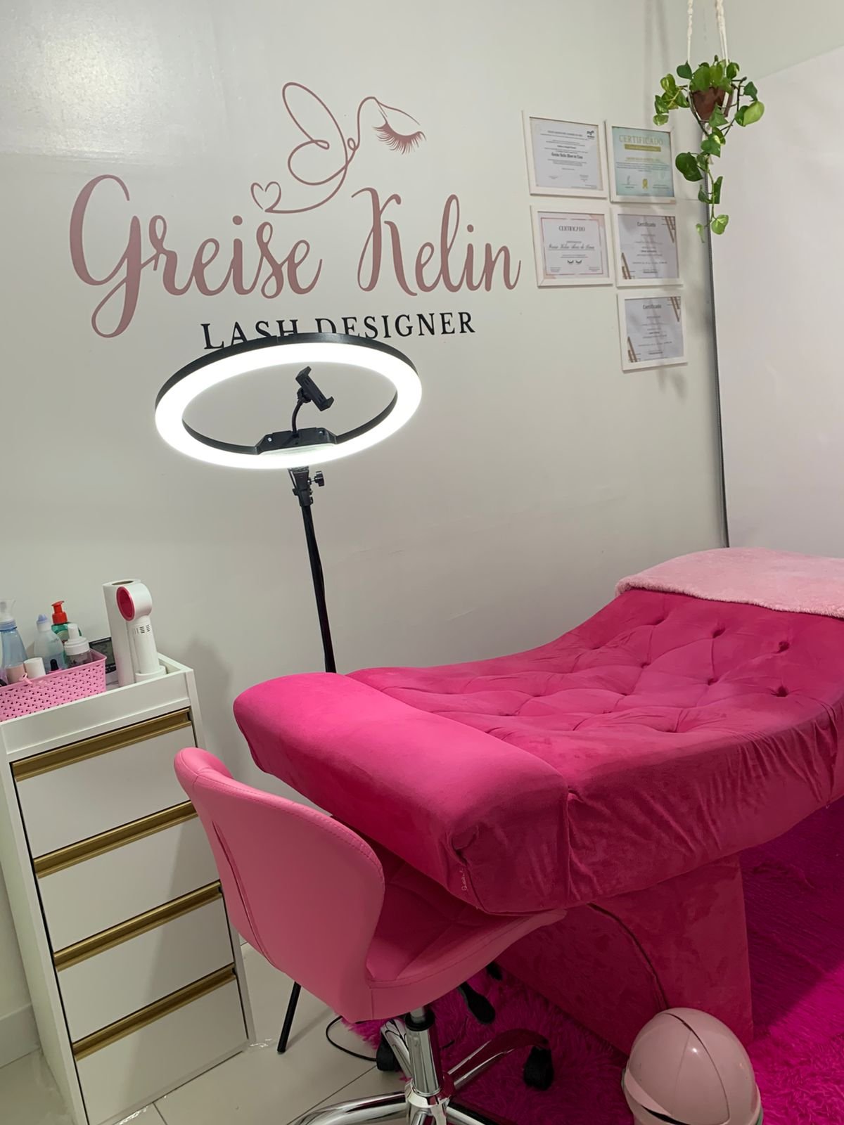 Sala de atendimento da GK Lash & Beauty com maca rosa, iluminação profissional e certificados na parede, ambiente aconchegante e moderno para procedimentos de cílios e sobrancelhas