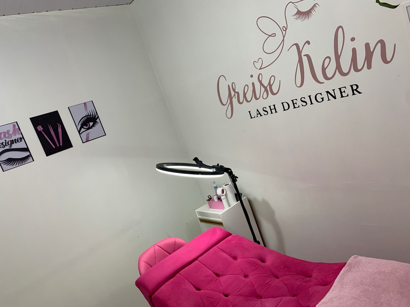 Ambiente do estúdio GK Lash & Beauty com maca rosa, iluminação de led, quadros decorativos e logo na parede, ideal para procedimentos de lash designer e estética facial